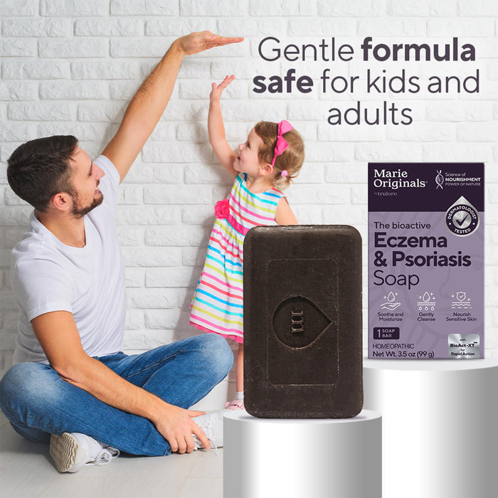 A smiling man and young girl touch hands by a white brick wall. In front, Marie Originals Eczema & Psoriasis Relief Soap and its packaging are displayed, highlighting safe relief for kids and adults.