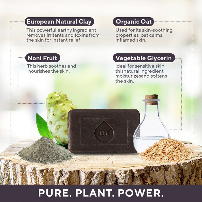 Marie Originals Eczema & Psoriasis Relief Soap rests on wood, surrounded by European clay, noni fruit, organic oat, and vegetable glycerin. This soap soothes and nourishes skin with pure ingredients for eczema relief.