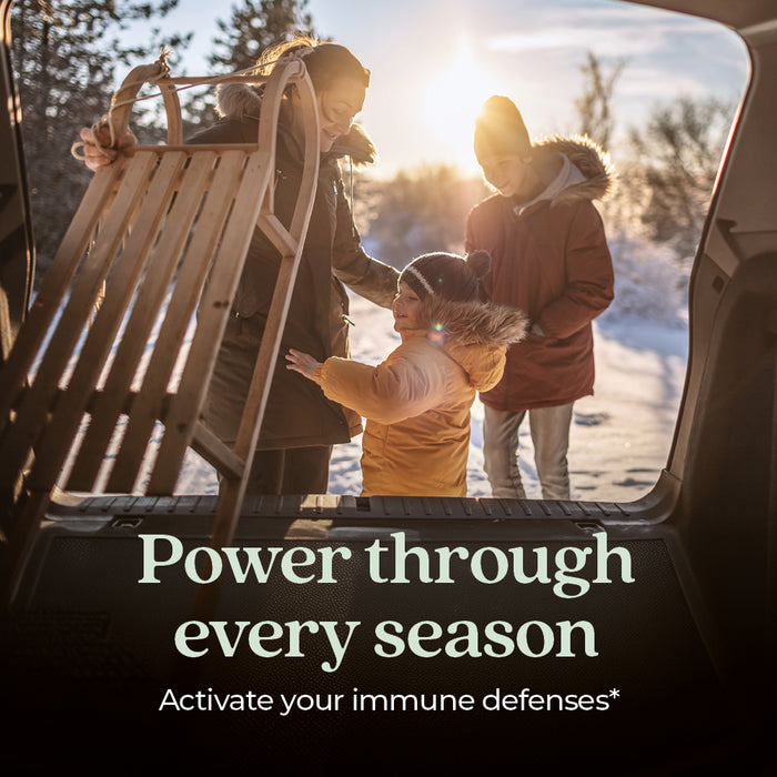 A family loads a wooden sled into a car on a snowy day. The sun is shining, and everyone is dressed warmly. Text reads: Support your immune system every season with Elderberry Force™ from New Chapter.*.