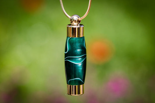 Emerald green acrylic keepsake urn pendant with gold caps for cremation ashes or hair on a gold chain