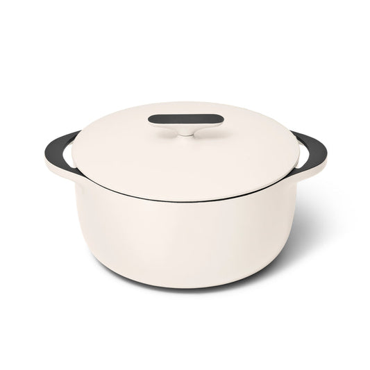 Caraways 6.5 qt Cast Iron Dutch Oven with Flat Lid is a sleek, white enameled pot featuring black handles and lid, offering superior heat retention while sitting elegantly against a plain white background.