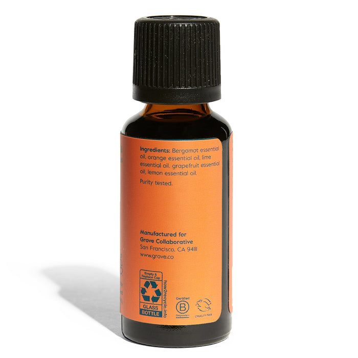 A small dark amber glass bottle with an orange label features the Energize Essential Oil Blend - Bergamot & Citrus by Grove Co. It lists organic essential oils like bergamot, orange, lime, grapefruit, and lemon. Marked Purity tested, its perfect for aromatherapy.