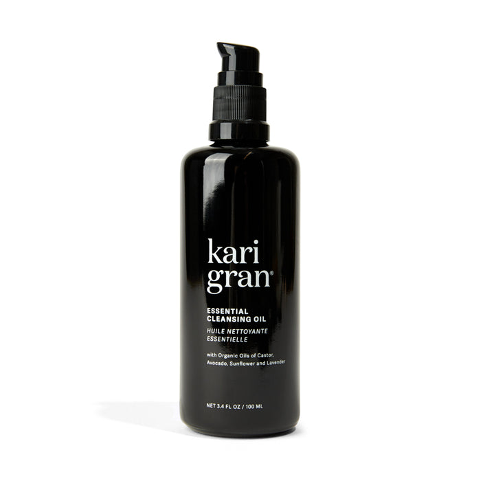 The 3.4 fl. oz. black pump bottle of Kari Grans Essential Cleansing Oil features organic oils like avocado, sunflower, and lavender for a hydrating cleanse and effective makeup removal.