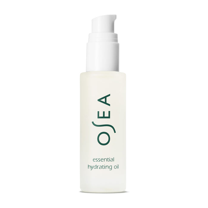 A clear bottle of OSEA Essential Hydrating Oil with a white pump promises a glowing complexion. OSEA is printed vertically in green, above smaller text reading essential hydrating oil, all set against a plain white background.