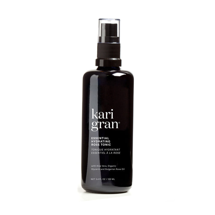 A black spray bottle labeled Essential Hydrating Tonic by Kari Gran is designed to rehydrate skin with a mix of aloe vera, organic glycerin, and Bulgarian rose oil. This 3.4 fl. oz. (100 ml) tonic is elegantly displayed against a white background.