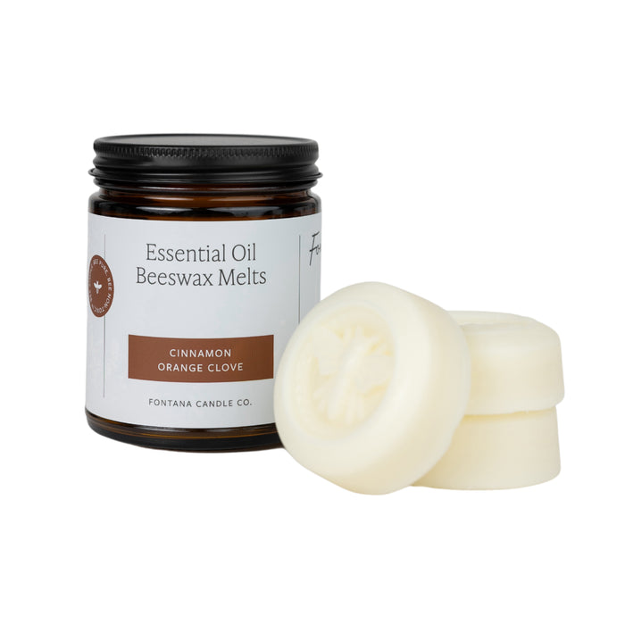 A jar of Essential Oil Wax Melts - Cinnamon Orange Clove from Fontana Candle Co., featuring non-toxic fragrance, is next to three round bee-imprinted wax melts.