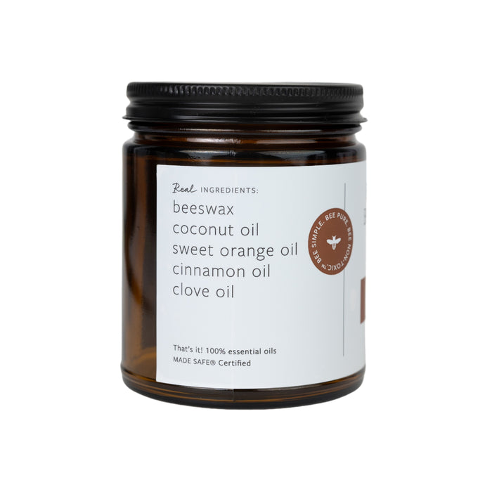 A Fontana Candle Co. Essential Oil Wax Melts jar features a black lid with a white label detailing ingredients like beeswax, coconut oil, sweet orange oil, cinnamon oil, and clove oil. The non-toxic aroma is from 100% essential oils and MADE SAFE certified.