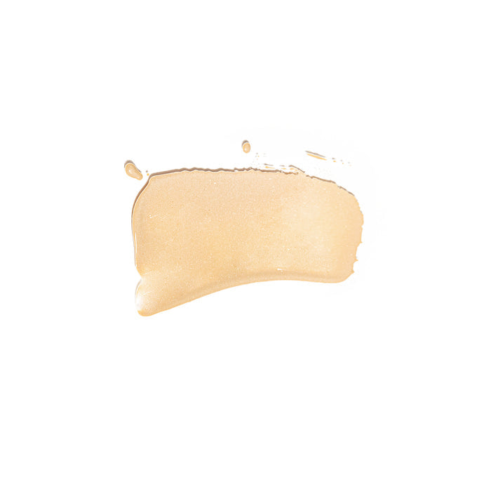 The Essential Tinted SPF 30 by Kari Gran, a beige, shimmering liquid with non-nano zinc oxide, effortlessly glides over the skin against a crisp white background.