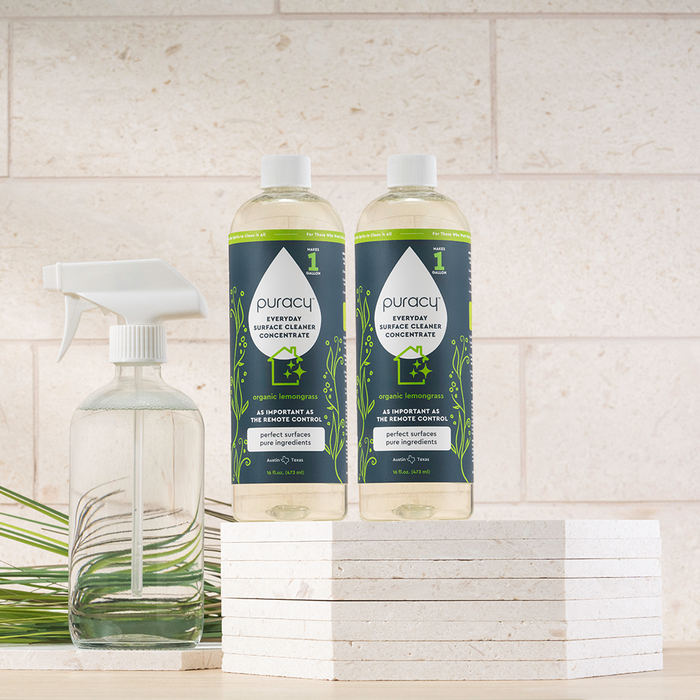 Two Everyday Multi-Surface Cleaner bottles and a spray bottle on stacked white tiles.