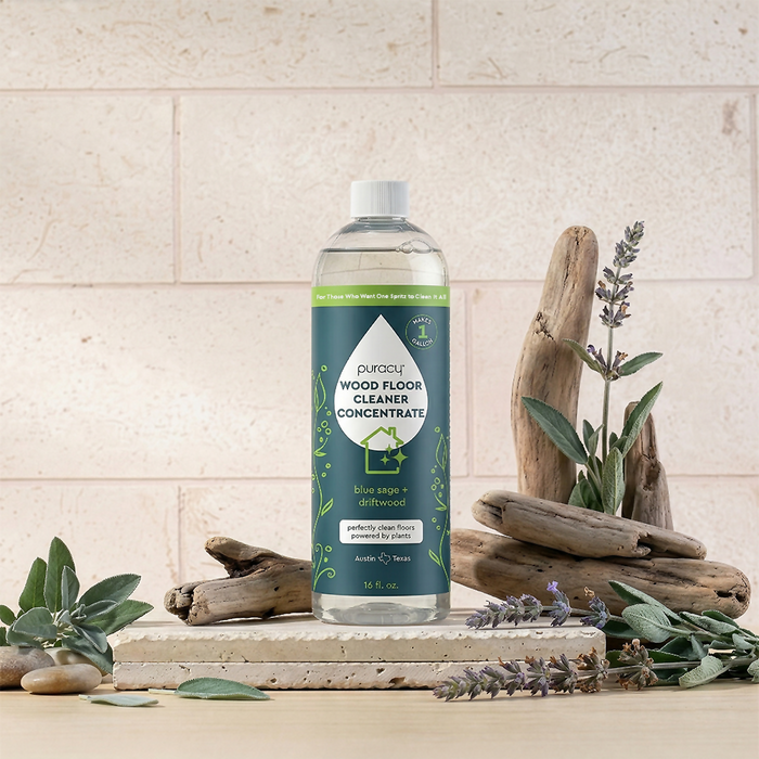 A bottle of Everyday Multi-Surface Cleaner sits on a table with driftwood and lavender sprigs.