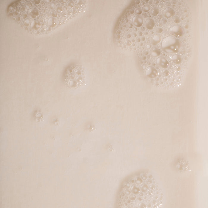 Close-up of bubbles on the creamy, beige surface of Phil’s Everything Bar. The chia seed oil enhances the bubbles’ varying sizes, giving the bar a textured and slightly foamy look.