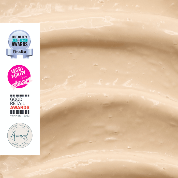 Close-up of a beige, creamy texture filling the frame. On the left, there are various award badges, including "Beauty Global Awards Finalist," "Vegan Beauty Award Winner," "Good Retail Awards Winner 2023," and "Sustainability Award Winner 2021.
