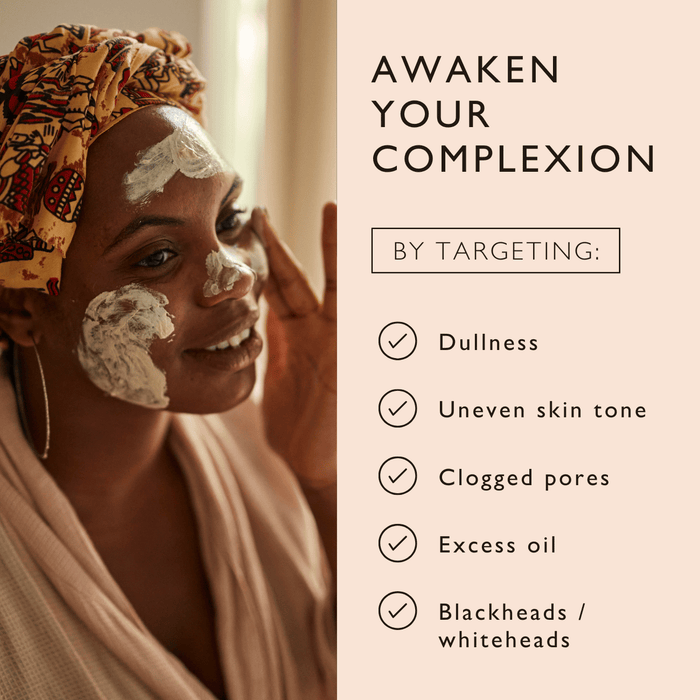 A person smiles and applies a face mask, wearing a colorful head wrap. Text beside them reads: "Awaken your complexion by targeting: Dullness, Uneven skin tone, Clogged pores, Excess oil, Blackheads/whiteheads.