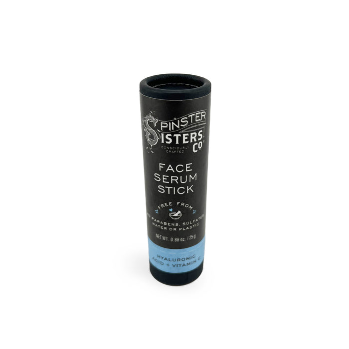 A black cylindrical tube labeled Spinster Sisters Co. Face Serum Stick showcases a formula free of parabens, sulfates, and phthalates. It contains hyaluronic acid, blue tansy oil, and vitamins, with packaging weighing 0.5 oz or 15 g.