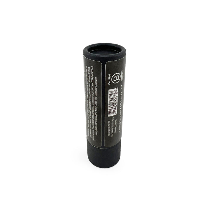 A cylindrical black tube stands upright on a white background, showcasing Spinster Sisters Co.s logo and details. It features white text and a barcode, highlighting the Face Serum Stick with Hyaluronic Acid + Vitamin C for enhanced skincare benefits.