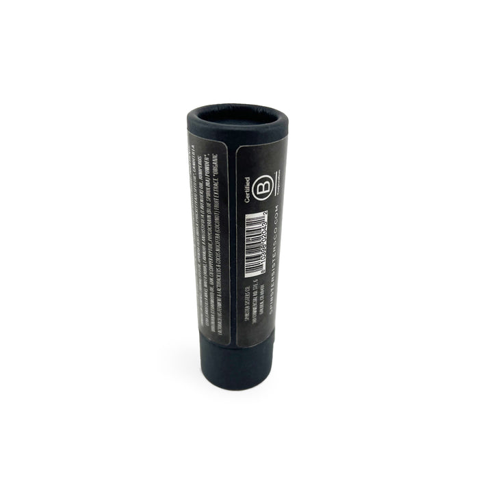 The black cylindrical tube labeled Spinster Sisters Co. holds the Face Serum Stick with Triple Peptide + Prickly Pear, standing upright on a white background, featuring a barcode and text that hint at its skin revitalization secret.