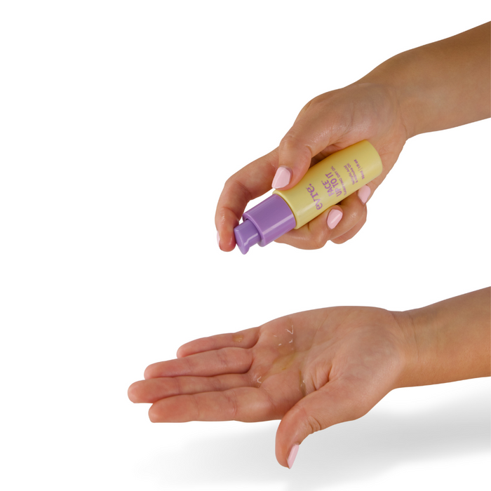 Hands dispensing Face Up To It Clarifying Dry Oil by evre., infused with Mā̄nuka oil, from a yellow bottle with a purple pump into an open palm against a white background.