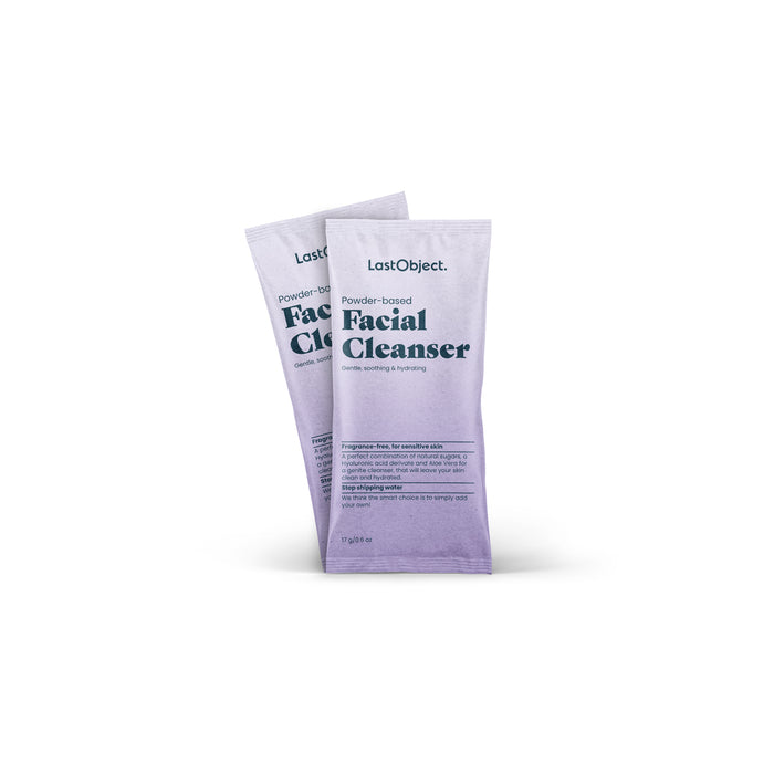 Two sachets of LastObjects Facial Cleanser Refill, designed to gently exfoliate and purify sensitive skin, are displayed. The packaging showcases a beautiful light-to-dark purple gradient.