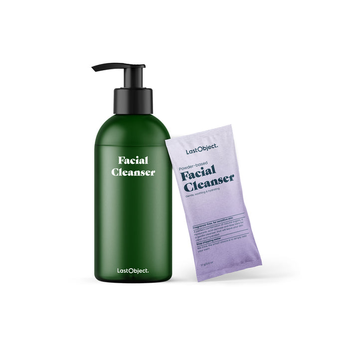 The LastObject Facial Cleanser Starter Set features a green pump bottle infused with a hyaluronic acid derivative and a purple sachet. Displaying the brands elegance, the bottle stands on the left with the sachet leaning gracefully against it on the right.