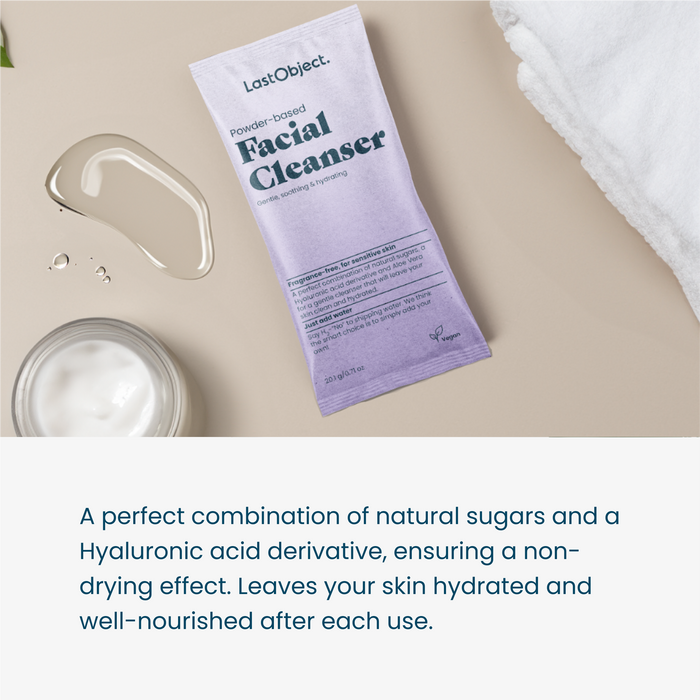 A lavender-colored pouch labeled "LastObject Powder-based Facial Cleanser" lies on a beige surface with a clear liquid spill, a small glass container of white cream, and a white cloth. Text below describes the product's hydrating and nourishing properties.