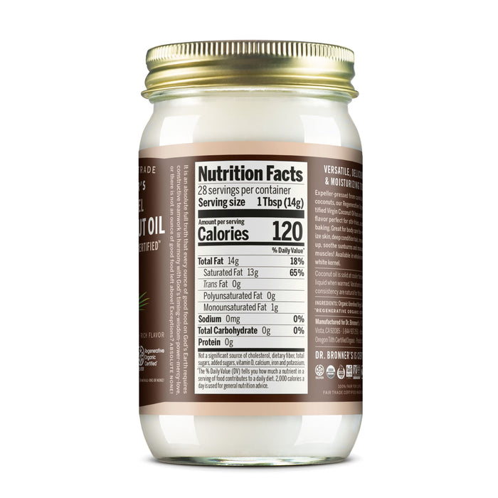 A clear jar of Dr. Bronner’s Fair Trade & Organic Whole Kernel Virgin Coconut Oil with a gold lid displays the nutrition facts: 120 calories and 14g fat per 1 tbsp serving, revealing the white organic coconut oil inside.