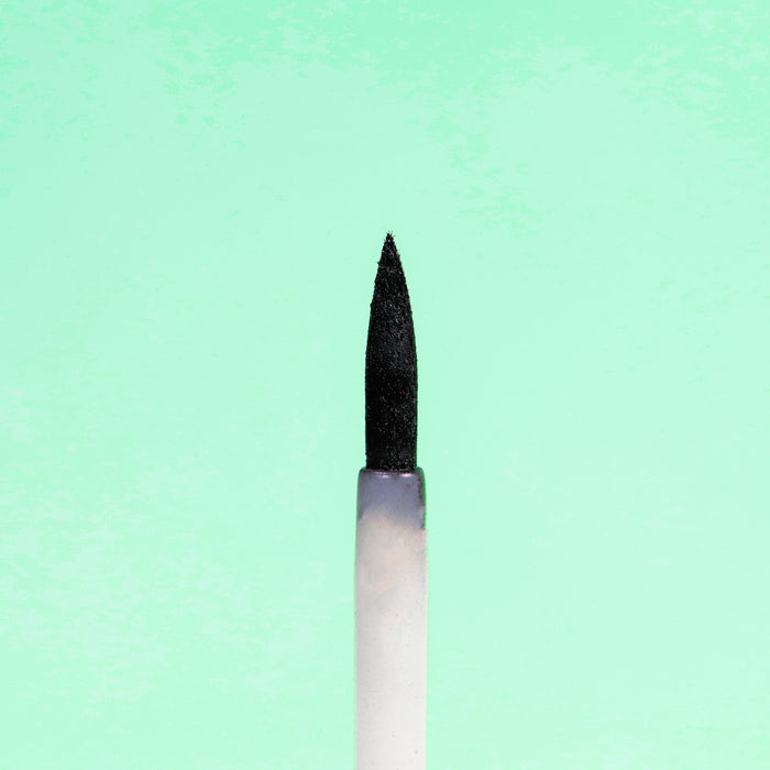 A close-up shows Everyday For Futures Felt Tip Avocado Eyeliner, with its textured black tip contrasting against a light green background. The pointed design is perfect for precise applications with style.
