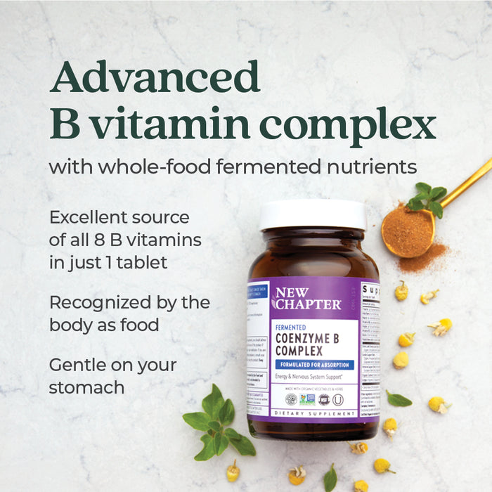 A bottle of New Chapter Fermented Coenzyme B Complex, Energy & Nervous System Support rests on a light surface, surrounded by green leaves, chamomile flowers, and a spoonful of orange powder, with its energy benefits highlighted nearby.