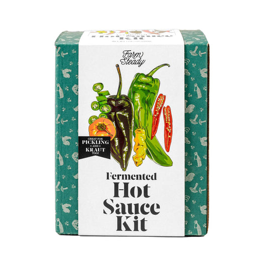 A green FarmSteady box labeled Fermented Hot Sauce Kit features a colorful array of peppers from red to yellow chilies. Ideal for making homemade hot sauce with umami richness, the background displays a charming pattern of small, white vegetables.