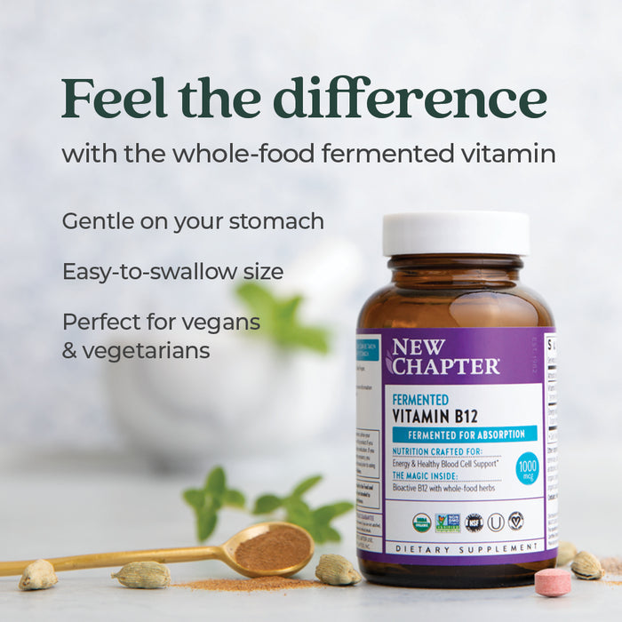 A bottle of New Chapter Fermented Vitamin B12 - For Cellular Energy + Healthy Blood Cells sits on a table with scattered pills, a wooden spoon, and a small bowl. Text notes its gentle on the stomach, easy to swallow, and vegan/vegetarian-friendly.