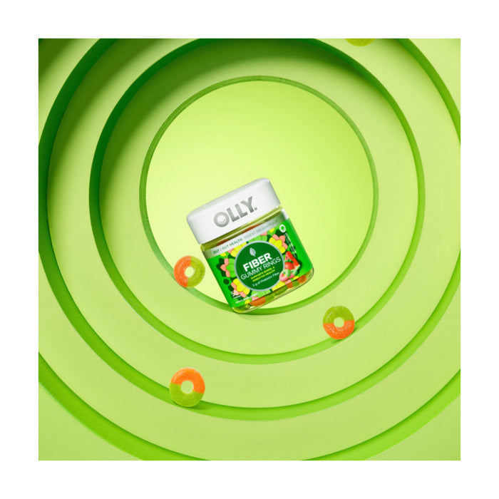 An OLLY Fiber Gummy Rings jar is encircled by green concentric rings. Vibrant and dynamic, the colorful gummies around the jar promote digestive health.