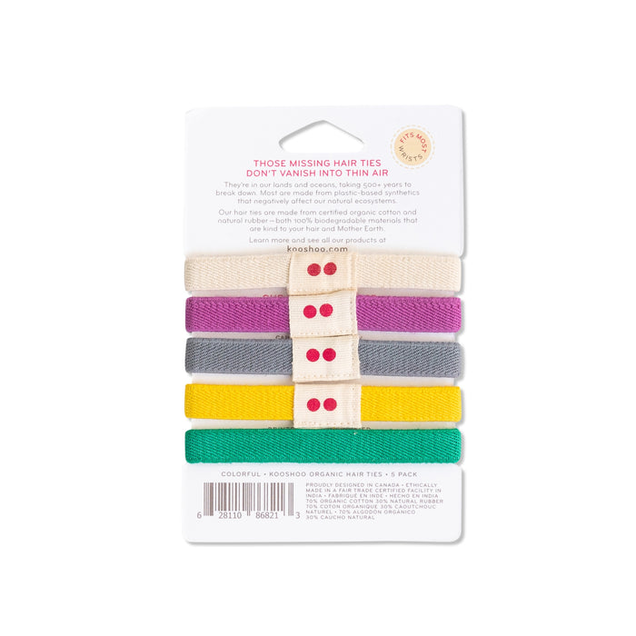 KOOSHOOs Organic Hair Ties offer a stylish and sustainable option with plastic-free elastics in cream, purple, yellow, gray, and green. Each pack of five comes in eco-friendly packaging featuring a central label adorned with red dots.