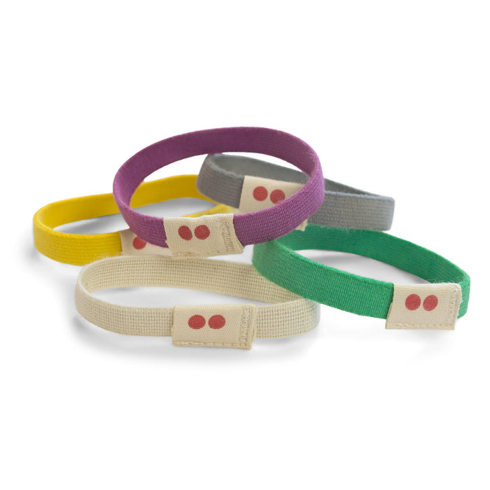 KOOSHOOs Organic Hair Ties, embodying sustainable fashion principles, come in five colors: purple, gray, green, yellow, and beige. Each features a small tag with two red dots. Theyre displayed overlapping on a white surface.