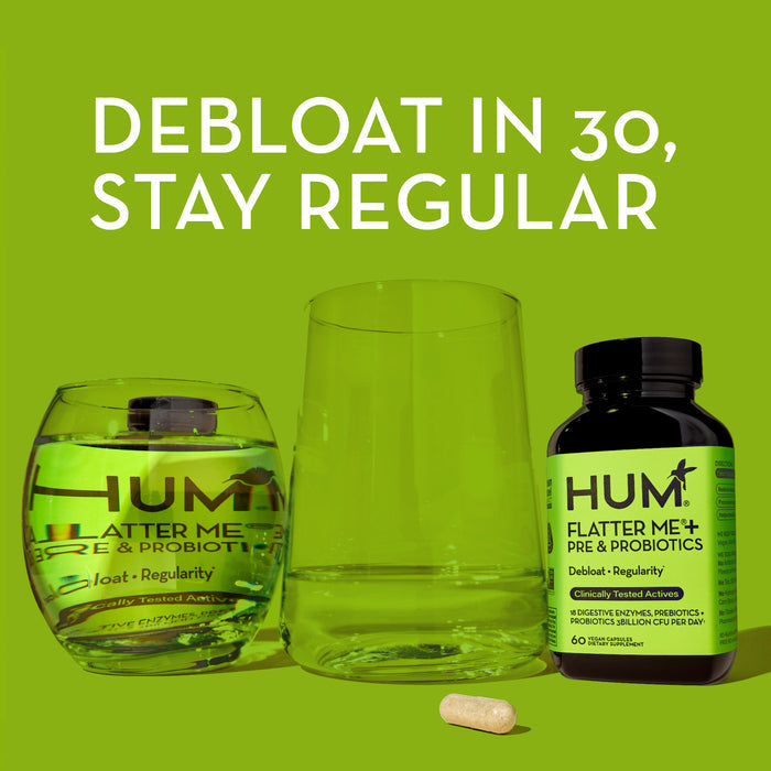 Two bottles of HUM Flatter Me+ Pre &amp; Probiotics are centered against a green background, one pill placed in front. Text above reads, "Debloat in 30, Stay Regular.