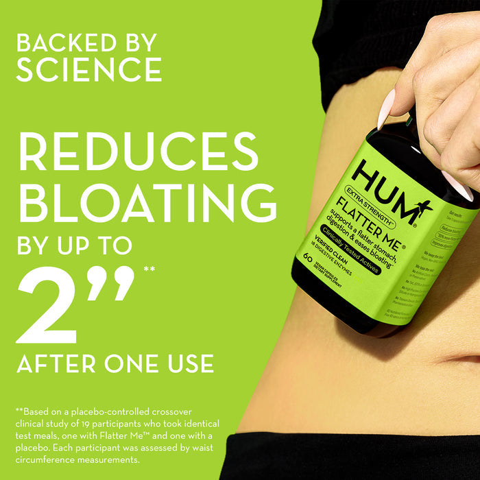 A hand holds a bottle of HUM Flatter Me dietary supplement against a bare midriff. The text reads, "Backed by Science. Reduces Bloating by up to 2 inches after one use." Note about a clinical study and measurements is included at the bottom.