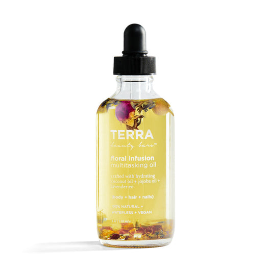 The Floral Infusion Multitasking Oil from Terra Beauty Bars comes in a clear glass bottle with a black dropper cap, enriched with natural oils and flower petals to nourish body, hair, and nails. Its label highlights its vegan and natural formula.