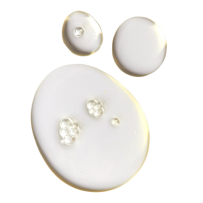 On a white background, three clear liquid droplets with air bubbles inside vary in size. The largest is elongated, while the smaller ones are round. Their glossy, reflective surfaces evoke the elegance of Terra Beauty Bars Floral Infusion Multitasking Oil for Body + Hair in your self-care routine.