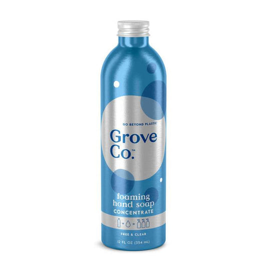 The Grove Co. Foaming Hand Soap Refill in a blue metallic 12 fl oz bottle highlights sustainable packaging with Go Beyond Plastic and Free & Clear text, featuring white/dark blue circles, and is made from plant-based ingredients for an eco-friendly and effective clean.