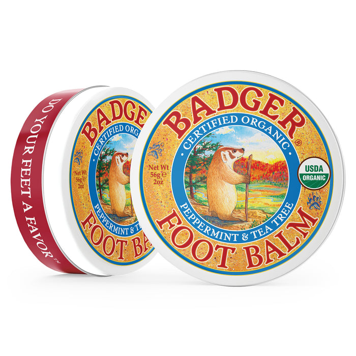 Two Badger Balm metal tins are displayed; the front tin features a badger with a staff in nature, labeled Certified Organic, Peppermint & Tea Tree, and Essential Oils. The side tin reads: Do Your Feet a Favor. Ideal for soothing cracked heels.
