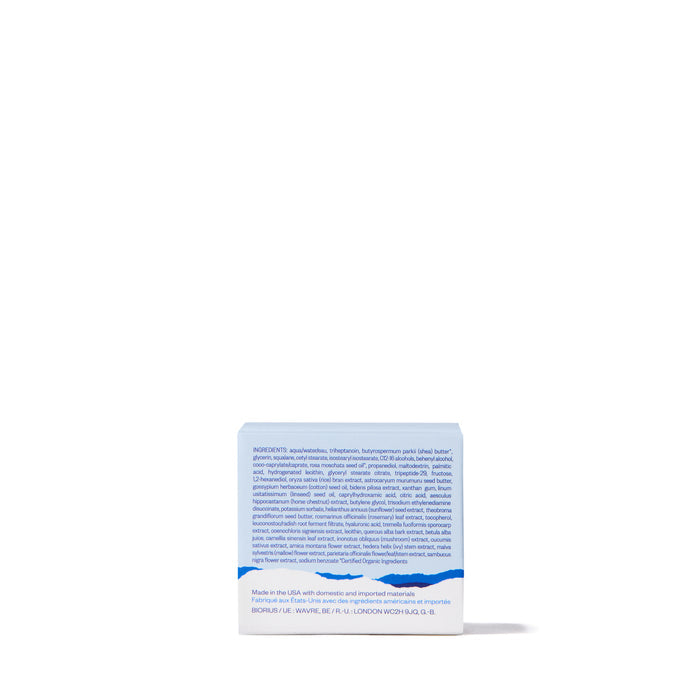 A small, square box with a blue and white design sits against a white background. Labeled as Ursa Majors Forest Alchemy Eye Cream, the packaging highlights its focus on fine lines and dark circles, with details above a wavy blue line on the back.