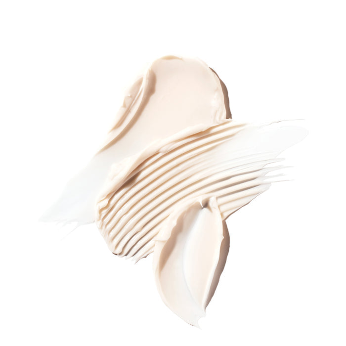 Ursa Major’s Forest Alchemy Eye Cream, a creamy beige formula, is swirled on a white background with smooth ridges—an ideal treatment for dark circles and fine lines.
