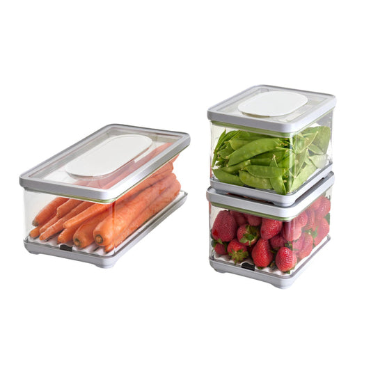 Three eco-friendly iDesign Fresh Produce Bins made with recycled plastic, featuring transparent bodies and white lids, efficiently cradle whole carrots, pea pods, and strawberries. Neatly stacked in two tiers, these bins extend the life of your fruits and veggies.