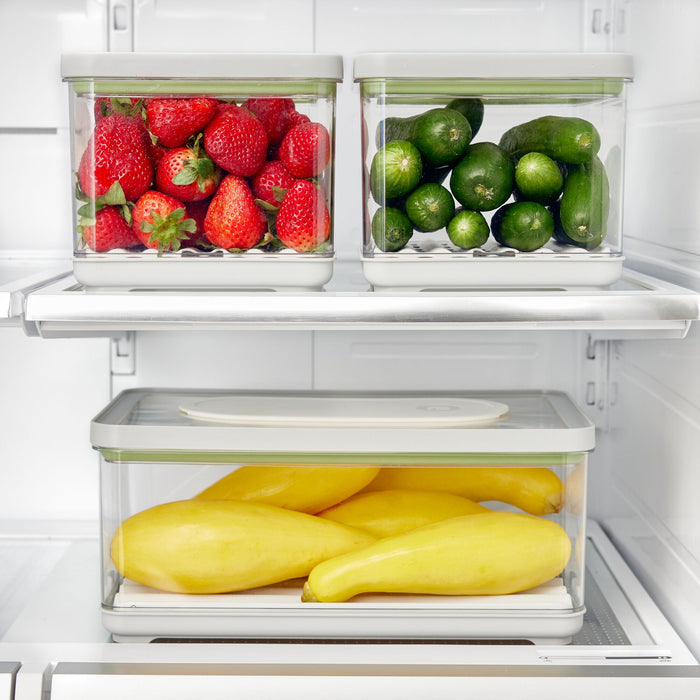 The iDesign Fresh Produce Bin Set, made with recycled plastic, includes three eco-friendly containers storing strawberries, cucumbers, and squash. Each features a white lid to keep produce fresh and neatly organized on your refrigerator shelves.