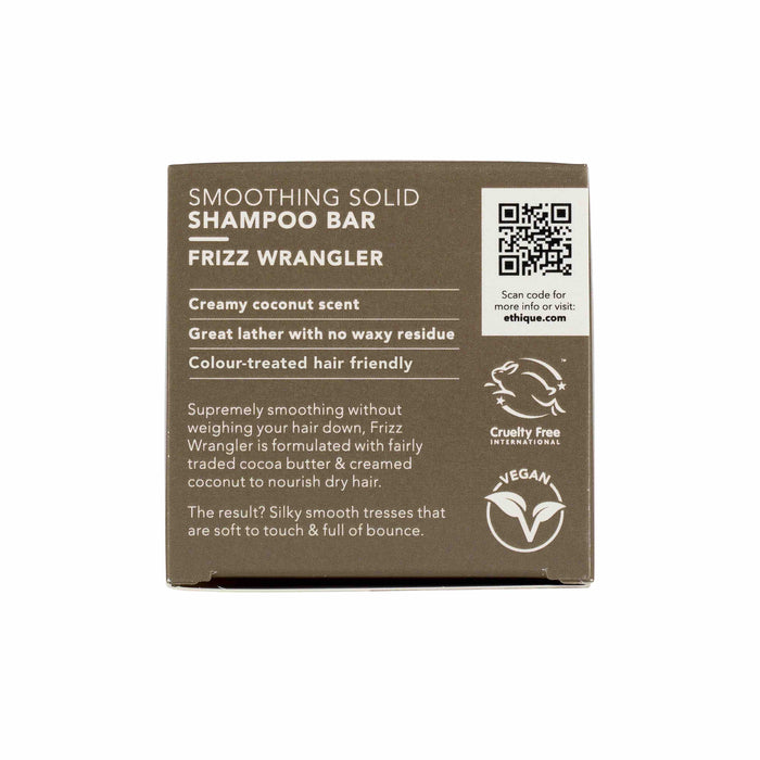 The image shows the back of an Ethique Frizz Wrangler Smoothing Shampoo Bar box, highlighting a creamy coconut scent, impressive lather, no waxy residue, and cruelty-free vegan credentials. Branding elements and a QR code are also included.