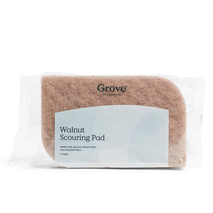 Grove Co.s Walnut Scouring Pads come in a pack of three non-abrasive cleaners made from sustainably farmed walnut shells and recycled fibers, elegantly presented in transparent packaging with minimal text to highlight their eco-friendly design.