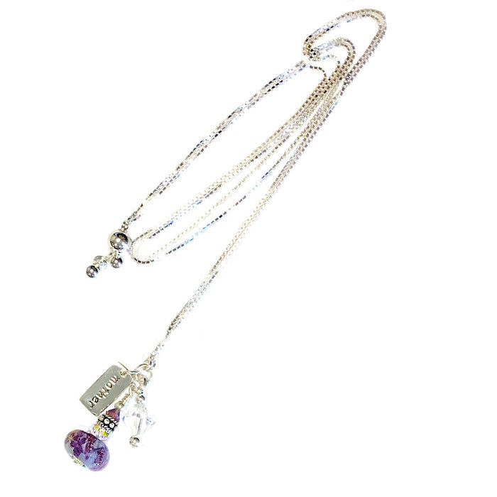 Multi strand silver necklace with a purple glass bead pendant and a mom tag among crystal accents