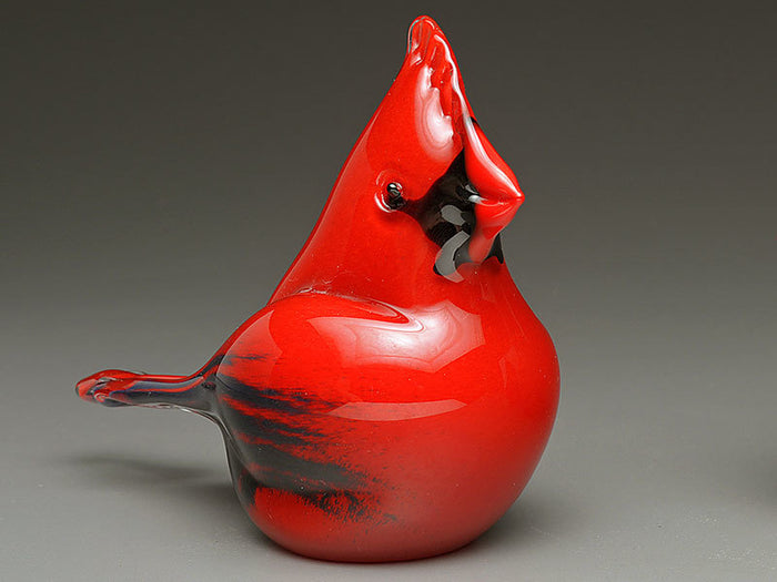 Red glass cardinal cremation keepsake photographed against a gray studio backdrop.