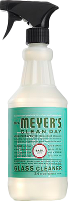 Mrs. Meyers Glass Cleaner in Basil scent, with a black spray nozzle and green label—an ammonia-free formula that leaves glass surfaces sparkling clean.