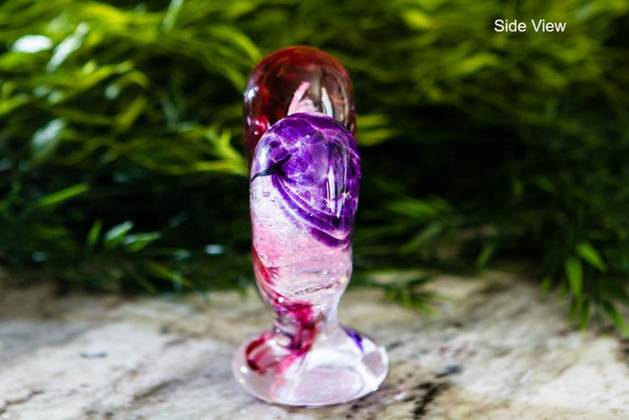 Side view of a glass standing heart in amethyst and gold ruby swirls, a cremation ash keepsake.