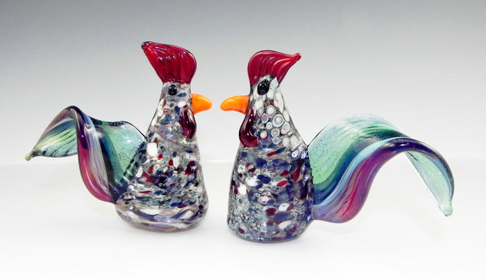 Pair of colorful glass rooster figurines infused with cremation ash at the base