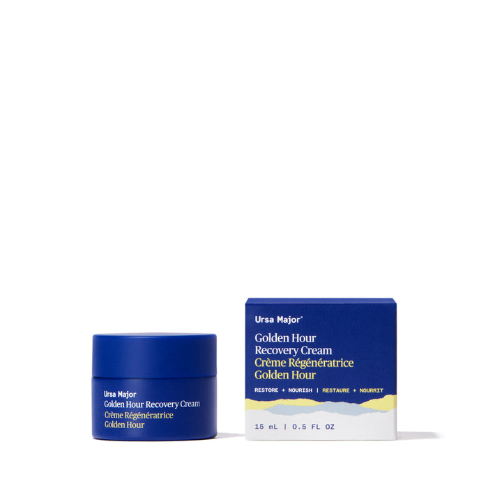A blue jar and matching box of Ursa Major Golden Hour Recovery Cream, a top facial moisturizer for deep hydration, sit on a white background. The packaging displays gold and white text with a wavy gold stripe at the bottom.